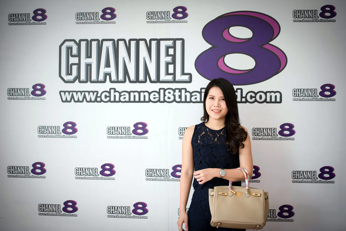 Dr. Waleerat standing in front of a Channel 8 Thailand media backdrop